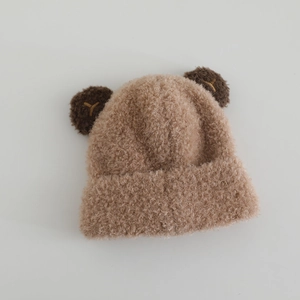 Detail der khakifarbenen Wintermütze mit flauschigen Bärenohren und Strickstruktur