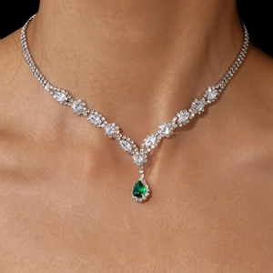 Detail of luxury water drop pendant necklace with green stone on model neck
