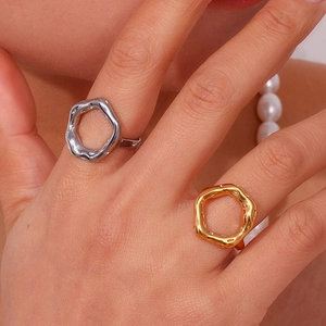 Irregular cutout ring in 18K gold and silver finish worn by a model in a luxury setting