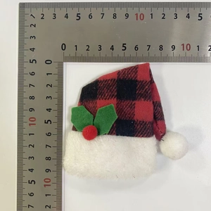Mini red and black plaid Christmas hat with holly detail and ruler for size scale