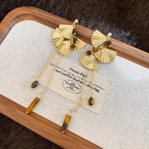Detail view of vintage ginkgo leaf earrings with tiger eye stone and long golden tassels