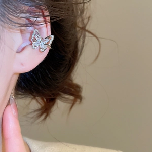 Close-up of a silver butterfly ear cuff featuring sparkling white cubic zirconia stones