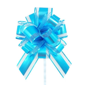 Detail of blue matte pull bow with mesh ribbon layers for holiday gift wrapping