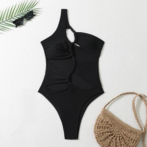 Détail d'un maillot de bain noir asymétrique avec texture tissée ajourée et maille côtelée