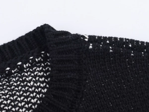 Macro detail of high-quality chunky knit texture on black and white jacquard cardigan