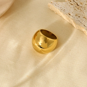 Chunky 18K gold plated stainless steel dome ring on a natural stone textured background