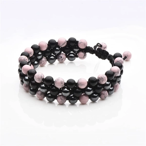 Detail of 8mm pink turquoise and black magnetic stones in a triple-layer braided bracelet