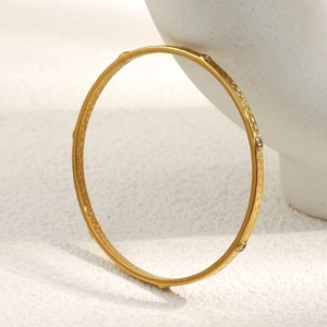 18K gold plated stainless steel bangle with hammered texture and small round diamonds