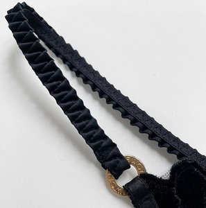 Macro detail of black velvet thong featuring a gold ring with Honey engraving