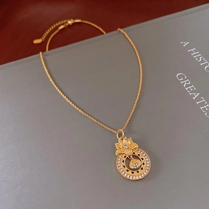 Macro shot of gold lotus pendant necklace with white crystals and intricate carving details