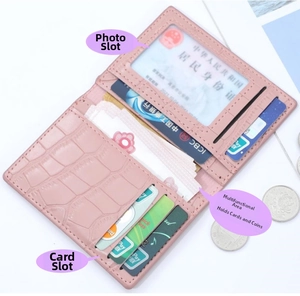 Detail view of pink crocodile-embossed card holder featuring photo slot and card compartments