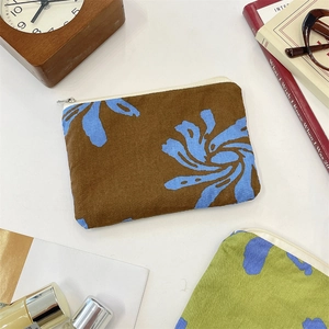 Detail of dark brown linen organizer bag with blue floral pattern and zipper closure