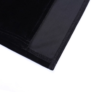 Détail de la texture du velours noir et coutures précises sur la fente de la robe