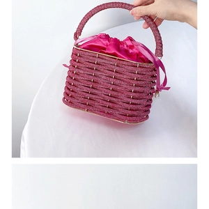 Detailed view of fuchsia beaded bucket bag with satin drawstring and pearl charm
