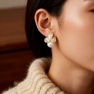 Elegant gold flower pearl earrings with sparkling crystals worn by a model in a close-up shot