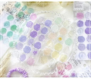Detailed macro view of macaron colored wax seal stickers with 3D embossed floral patterns