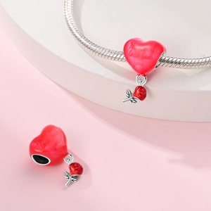 Detailed macro view of heart enamel pendant with rose charm and Never love but you engraving