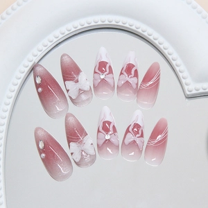 Almond-shaped cat eye press-on nails with 3D bows, rhinestones and pink gradient effect