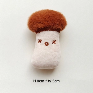 Detail of 8cm mushroom plush charm with faux fur cap and XOX embroidery on white background