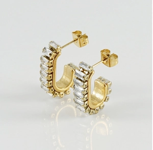 Macro shot of 18K gold U-shaped earrings featuring baguette-cut zircon channel setting