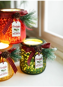Close-up of glowing Christmas glass jars with pine cones and festive ribbon bows
