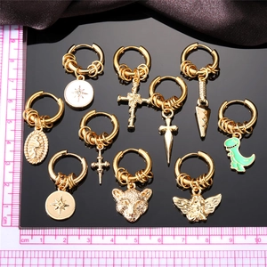 Set of 10 gold stainless steel hoop earrings with cross and dinosaur charms shown with ruler