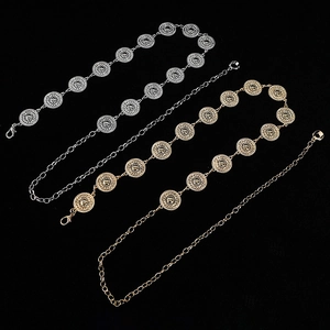 Macro view of gold and silver metal waist chains with hollow round patterns on black background