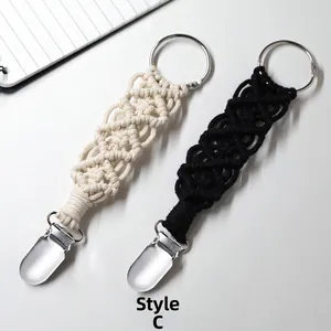 Detail of macrame hat clips for travel bags in black and beige woven cotton with metal clips