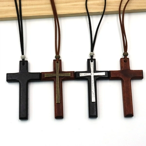 Details von handgefertigten Holzkreuz-Anhängern mit Lederkordeln und Metallelementen
