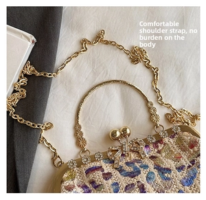 Close-up of woven evening bag with rhinestone bow detail and gold metal handle