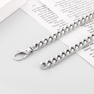 Detail view of silver Cuban chain strap with lobster clasp on a book background