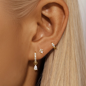 Close-up of s925 silver earring set with gold plating and white zircon on model