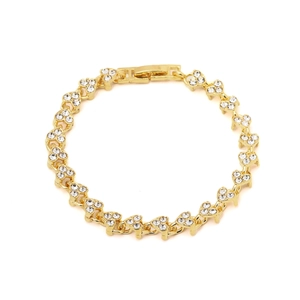 Detail of gold heart link bracelet with sparkling rhinestones on white background