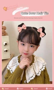 Detailed close-up of pink bow hair ties with pleated fabric texture on a young girl