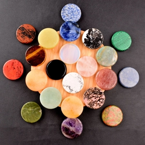 Artistic arrangement of 40mm natural crystal gemstone discs on a bamboo tray