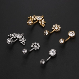 Macro shot of titanium steel navel rings in gold and silver finish with sparkling zircons