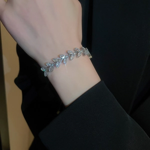 Gros plan d'un élégant bracelet feuille en argent avec zircons taille marquise au poignet