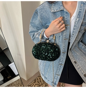 Detail of dark green sequin evening clutch bag with gold handle and rhinestone clasp