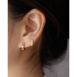 Close-up of gold S925 silver hoop earrings with inset rectangular colored zircons