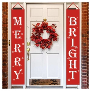 Detail of red Merry and Bright door banners hanging on a white door with autumn wreaths