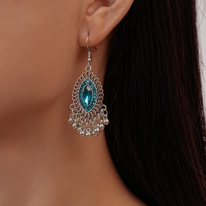 Vintage silver hollow geometric earrings with blue crystals and tassels on model