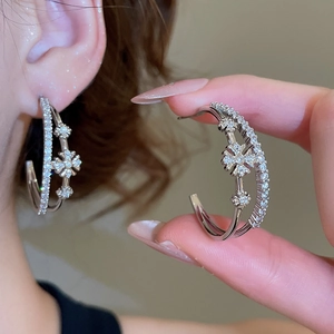 Détail des boucles d'oreilles doubles en C avec motif flocon en zircone cubique