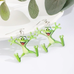 Detalle de pendientes de rana en acrílico translúcido verde para ocasiones festivas