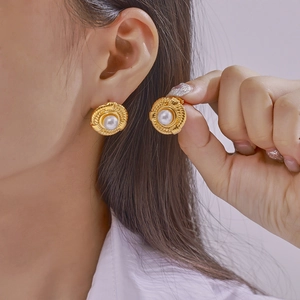 British style twisted gold earrings with pearl inlay on a geometric metal design