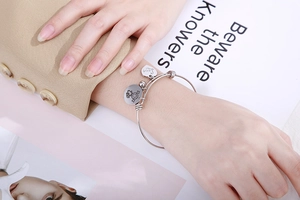 Detail of adjustable silver bracelet with heart 'Love' charm and sliding clasp mechanism