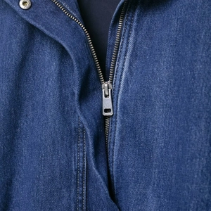 Detail of dark blue vintage denim jacket featuring premium silver metal zipper and stitching