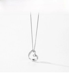 Detail of s925 silver necklace with asymmetric hollow heart pendant and zircon pavé