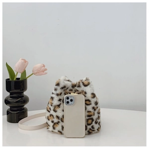 Detail view of plush leopard print bucket bag with metal chain and phone for scale