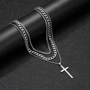 Detailed close-up of triple-layered silver stainless steel necklace with cross pendant