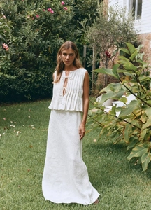 Detail of white cotton linen two-piece set with vertical pleats and tie-front closure